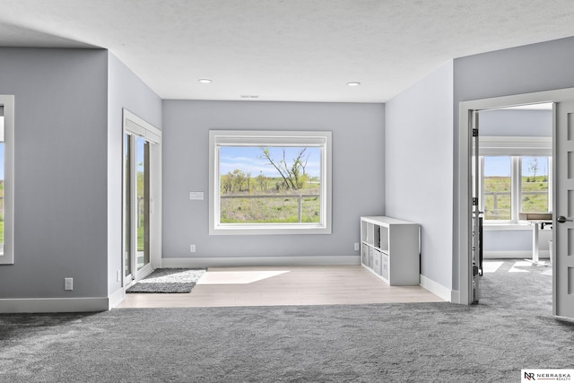 doorway to outside with baseboards, carpet flooring, and recessed lighting