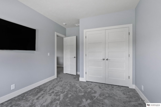 unfurnished bedroom with carpet floors, baseboards, and a closet