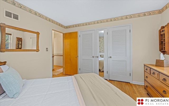 bedroom featuring visible vents, light wood-style floors, and baseboards