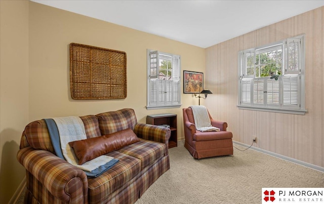 living area with baseboards and carpet