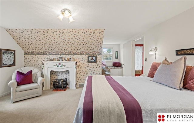 bedroom featuring carpet flooring, wallpapered walls, and an accent wall