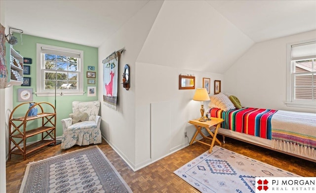 bedroom featuring baseboards, multiple windows, and lofted ceiling