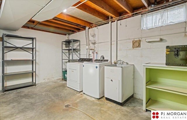 laundry room with independent washer and dryer, concrete block wall, and laundry area