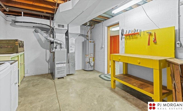 unfinished below grade area with a workshop area, independent washer and dryer, visible vents, concrete block wall, and water heater
