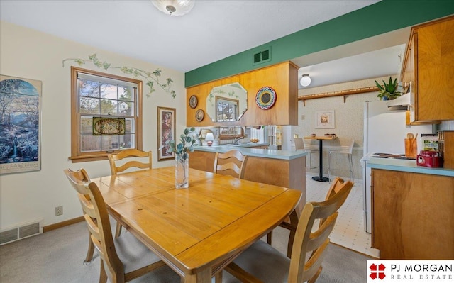 dining space featuring visible vents and light carpet