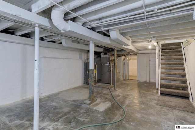 unfinished below grade area featuring stairway and heating unit