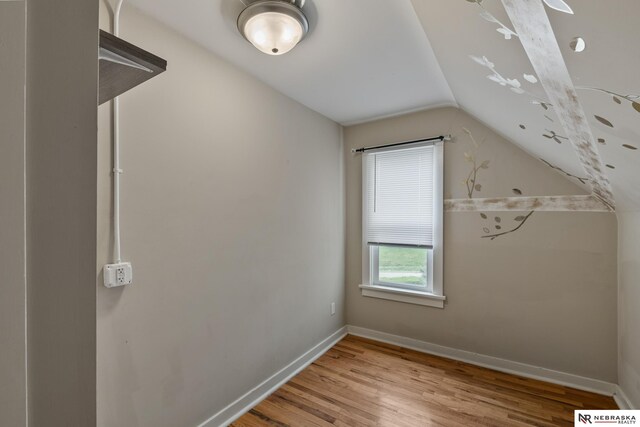 bonus room featuring lofted ceiling, baseboards, and light wood finished floors