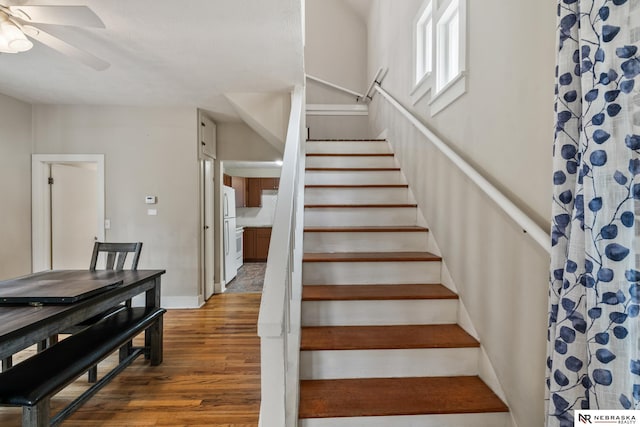 stairs featuring ceiling fan, baseboards, and wood finished floors