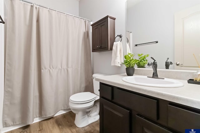 bathroom with toilet, vanity, wood finished floors, and a shower with shower curtain