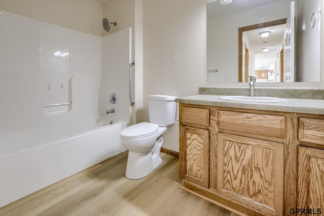 full bath with toilet, shower / bath combination, wood finished floors, and vanity