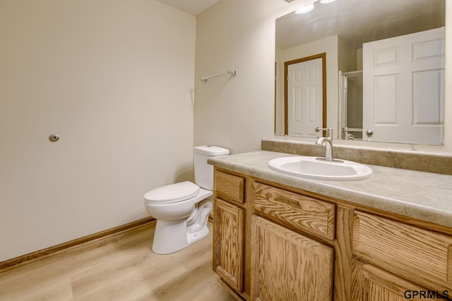 bathroom featuring vanity, wood finished floors, and toilet