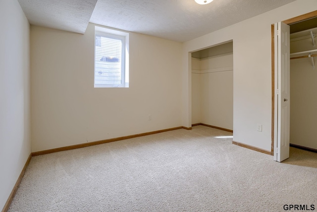 unfurnished bedroom featuring baseboards, carpet flooring, and a textured ceiling