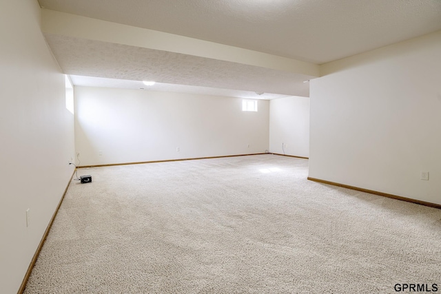 carpeted empty room featuring baseboards and a textured ceiling