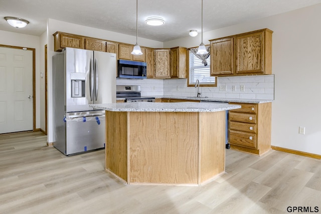 kitchen with a center island, a sink, light wood-style flooring, backsplash, and stainless steel appliances