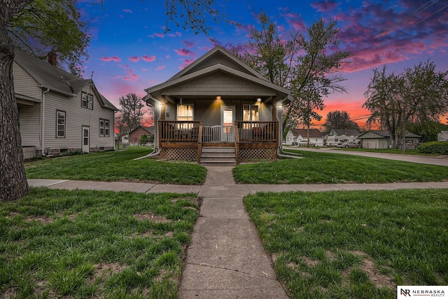 view of front of home with a porch and a yard