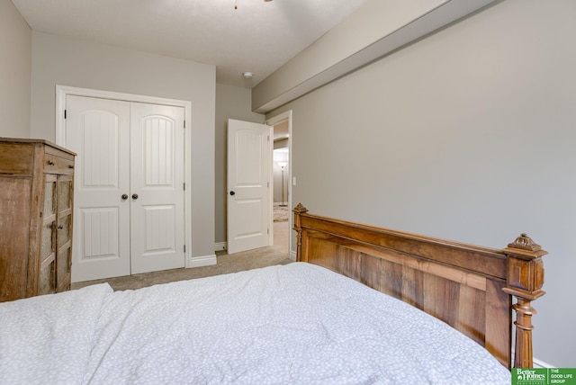 carpeted bedroom featuring baseboards and a closet