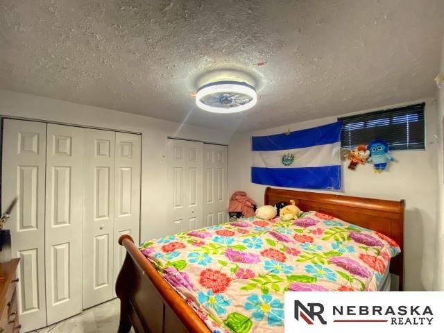 bedroom featuring two closets and a textured ceiling