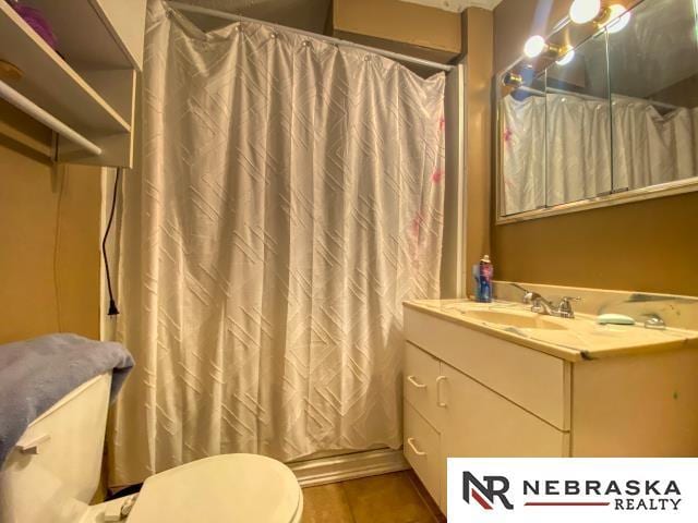 bathroom with vanity, a shower with shower curtain, and toilet