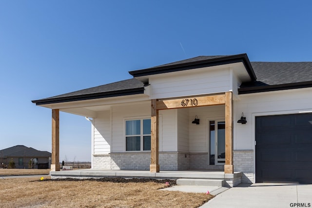 6710 S 207th Ave, Elkhorn, NE 68022 - view of front of house with a garage, a porch, roof with shingles, and stone siding