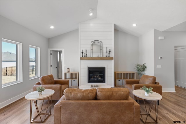 6710 S 207th Ave, Elkhorn, NE 68022 - living area with baseboards, vaulted ceiling, a large fireplace, and light wood finished floors