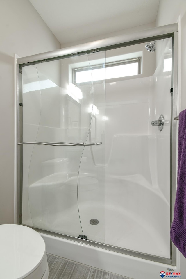 full bathroom with a stall shower and toilet