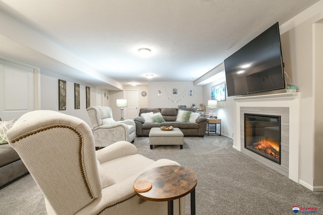 carpeted living room with a glass covered fireplace and baseboards