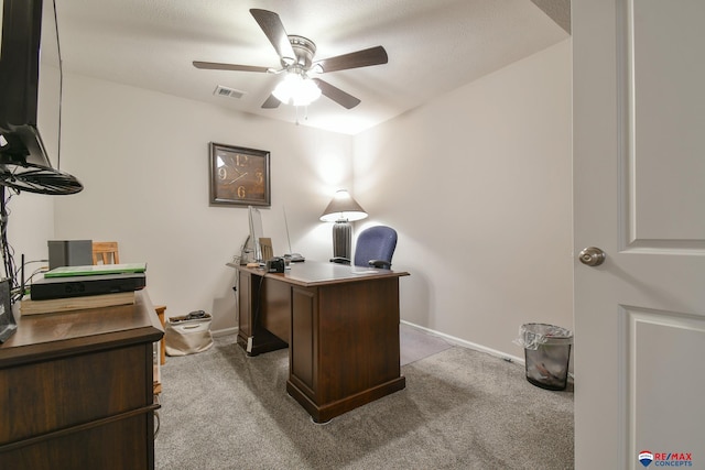 carpeted home office featuring baseboards, a ceiling fan, and visible vents