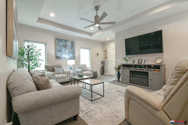 living room with a glass covered fireplace, ceiling fan, recessed lighting, and a wealth of natural light