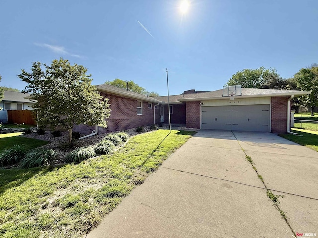 single story home with brick siding, fence, a front lawn, concrete driveway, and an attached garage