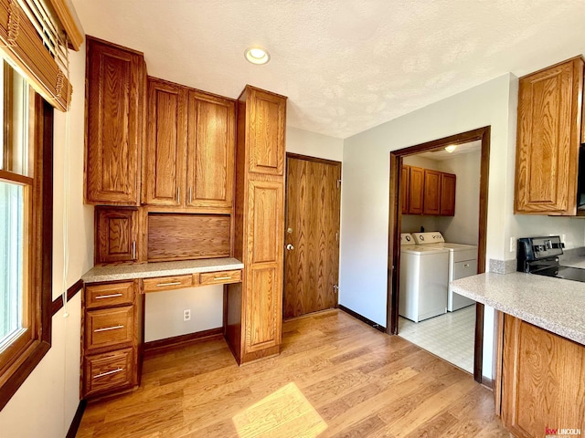 washroom with washer and clothes dryer, light wood-style flooring, and baseboards