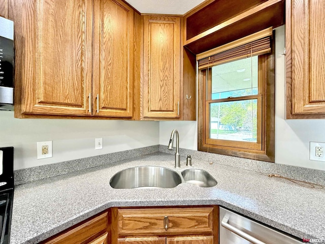kitchen featuring dishwasher, light countertops, brown cabinets, and a sink