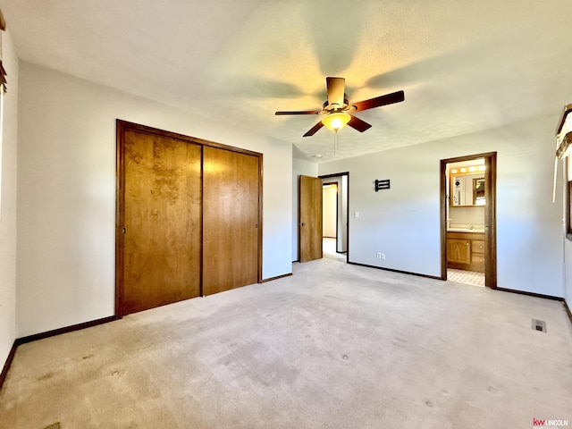 unfurnished bedroom featuring ensuite bathroom, light carpet, a closet, and baseboards