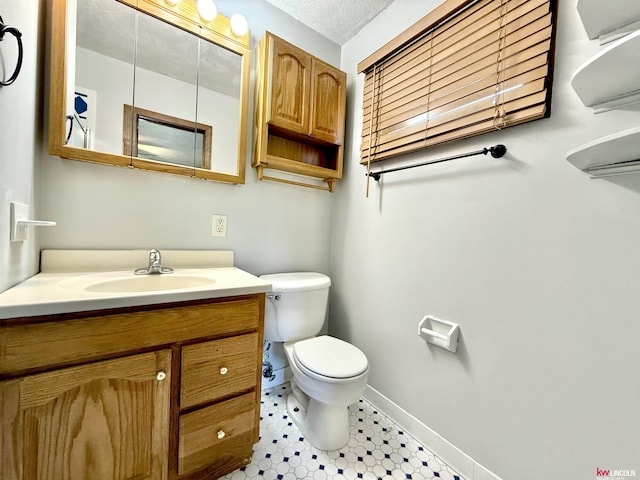 bathroom with toilet, baseboards, and vanity