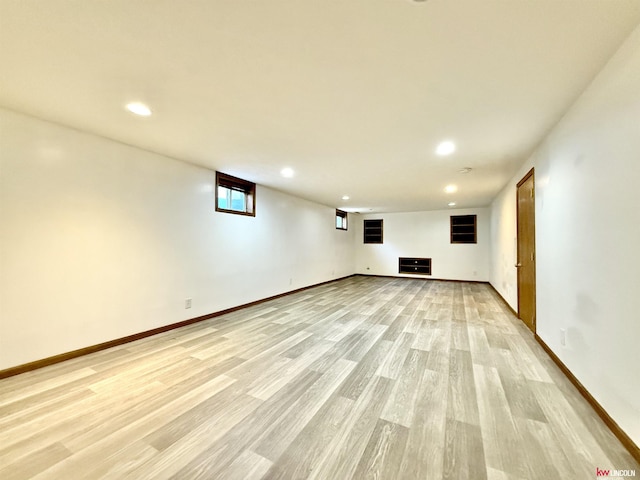 basement featuring baseboards, light wood finished floors, and recessed lighting
