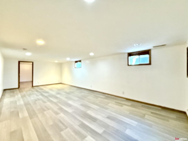 basement featuring light wood-style floors, baseboards, and recessed lighting