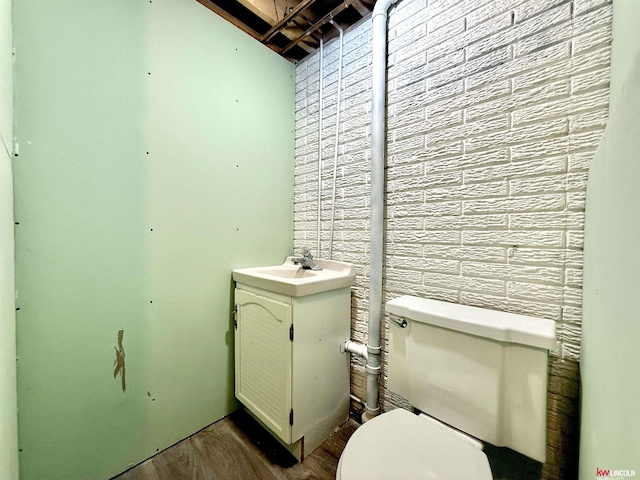 half bath featuring vanity, toilet, and wood finished floors