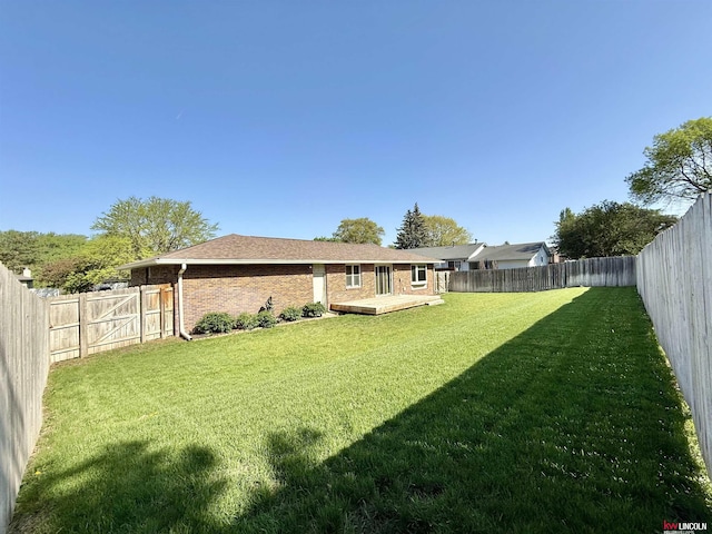 view of yard with a fenced backyard and a wooden deck