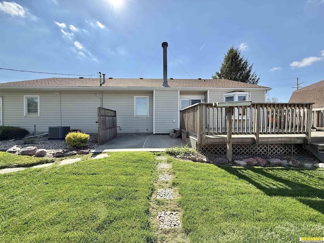 back of property with a yard, central AC, a wooden deck, and a patio area