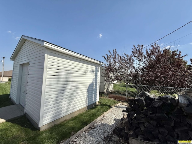 view of outbuilding with fence and an outbuilding