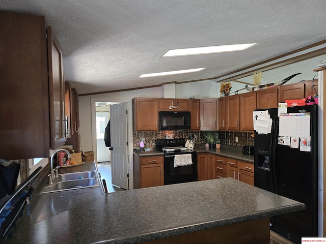 kitchen with a sink, a peninsula, backsplash, vaulted ceiling, and black appliances