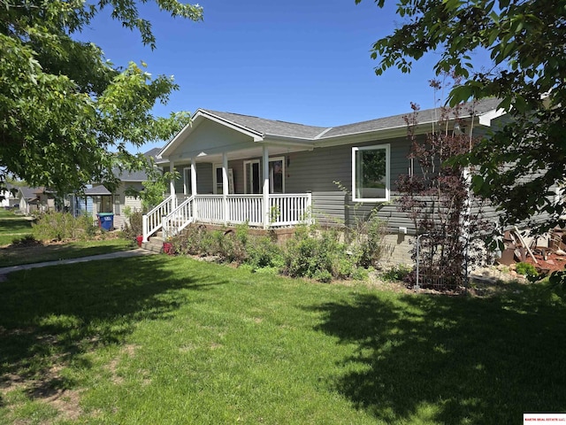 ranch-style home featuring covered porch and a front yard