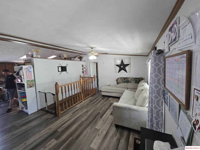 living area with ornamental molding, a ceiling fan, dark wood-style floors, and a textured ceiling