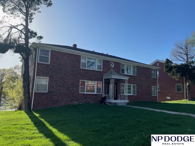 view of front of house featuring a front yard and brick siding