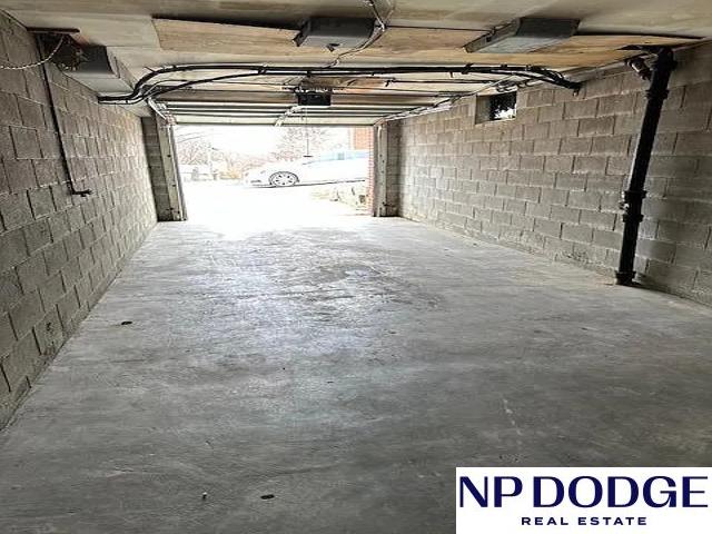 garage with concrete block wall and a garage door opener