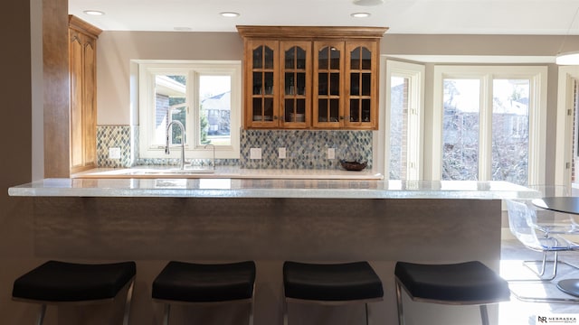 bar area featuring a sink, tasteful backsplash, and recessed lighting