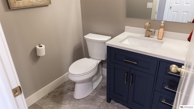 half bathroom with toilet, baseboards, and vanity