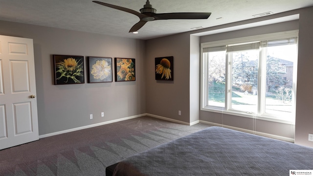 unfurnished bedroom with carpet, multiple windows, baseboards, and a ceiling fan