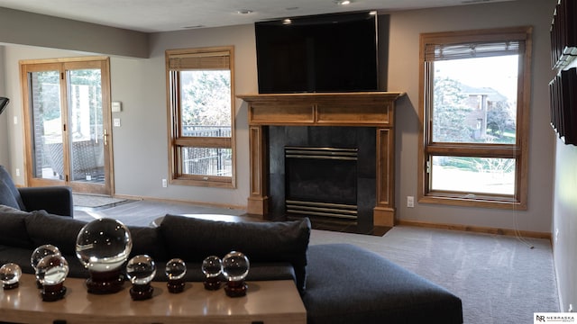 carpeted living room with baseboards and a tile fireplace