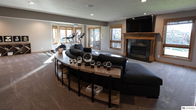 carpeted living area featuring plenty of natural light, a premium fireplace, recessed lighting, and baseboards