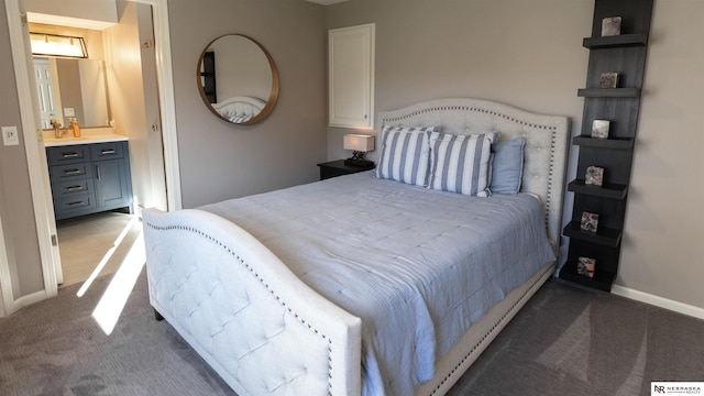 bedroom with carpet flooring, baseboards, bar with sink, and ensuite bath